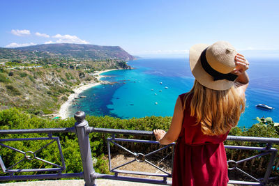 Rear view of traveler woman in capo vaticano on coast of the gods, calabria, italy.