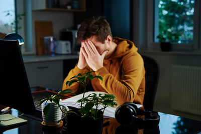 Tired man works late at workplace in the night