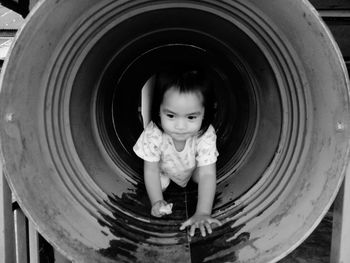 Cute girl crawling in empty drum