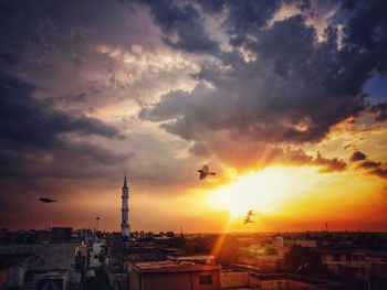 Buildings in city against sky during sunset