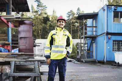 Portrait of happy carpentry student standing outside school building