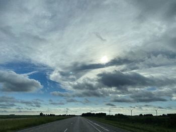View of country road against cloudy sky