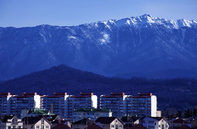 Buildings in city against blue sky