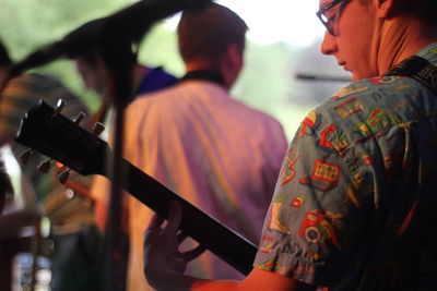 Young man playing guitar at music concert