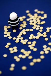 High angle view of stelline pasta with figurine on blue table