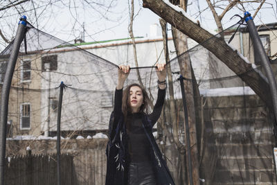 Portrait of woman standing by tree