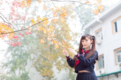 Portrait of young woman holding autumn leaves