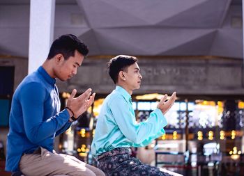 Side view of young man using mobile phone