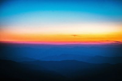 Scenic view of silhouette mountains against sky at sunset