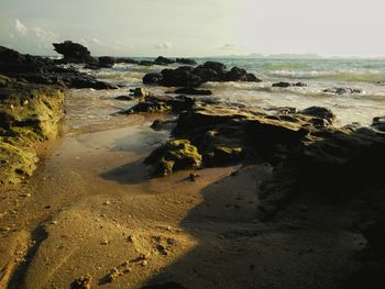 Rocks on beach against sky