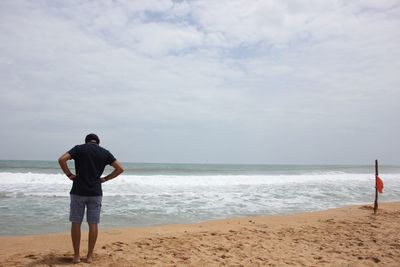 Full length of man standing on beach against sky