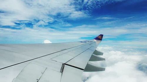 Digital composite image of airplane flying over clouds