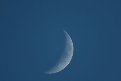 Low angle view of moon against blue sky