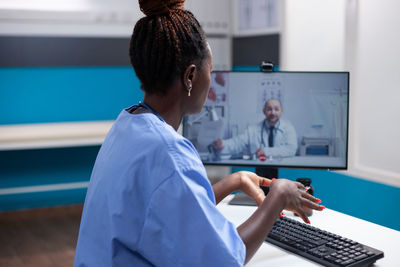 Side view of woman using laptop at office