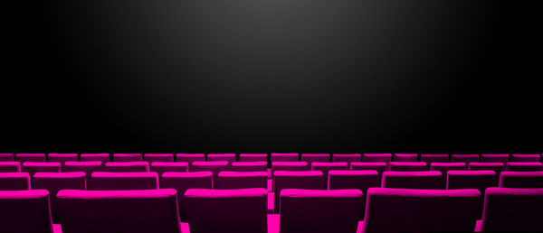 Empty chairs against black background