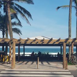 People sitting at beach against sky