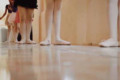 Low section of ballet dancers standing on floor