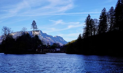 Scenic view of lake by trees against sky