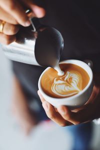 Close-up of hand holding coffee cup