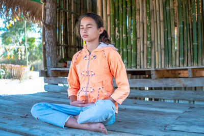 Girl meditating with eyes closed mind training in a quiet old wooden house