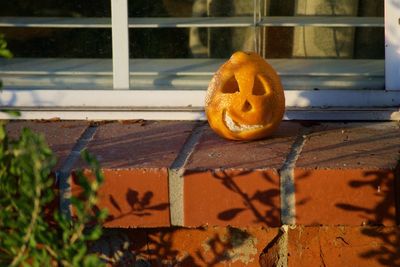 Close-up of pumpkin on metal window