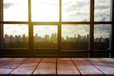 Modern buildings against sky seen through glass window