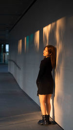 Rear view of young woman standing in tunnel