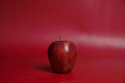 Close-up of apple against red background