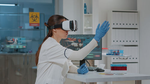 Young scientist wearing virtual reality simulator in laboratory