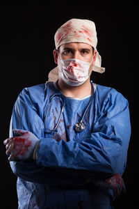 Portrait of senior man standing against black background