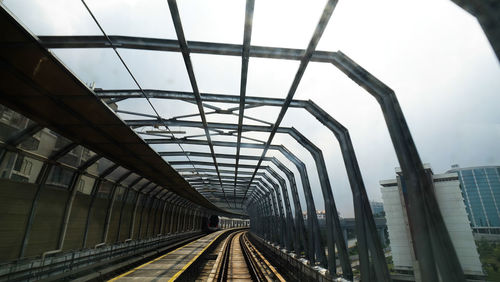 Railroad tracks in city against sky