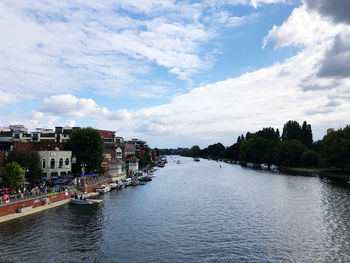 Buildings by river against sky in city