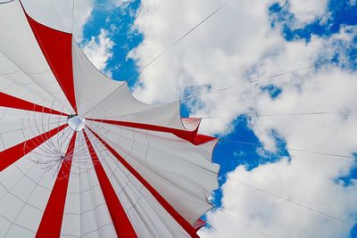 Low angle view of tent hanging against cloudy sky