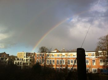 Rainbow over city against sky