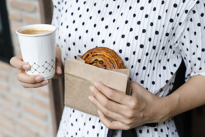 Midsection of woman holding coffee cup