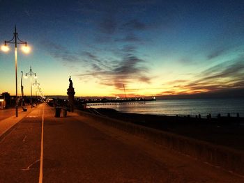 Narrow street leading to calm sea at dusk