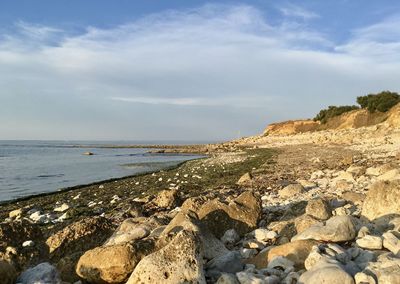 Scenic view of rocks on beach against sky