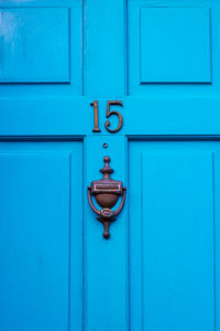 House number 15 on a blue wooden front door in london 