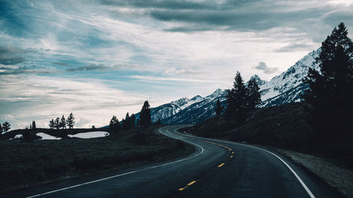 Road amidst trees against sky