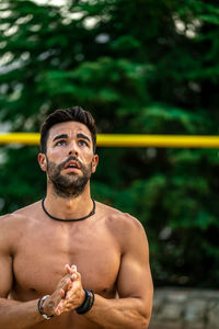 Young shirtless man exercising at playground