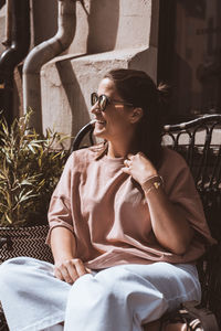 Woman wearing sunglasses sitting on chair