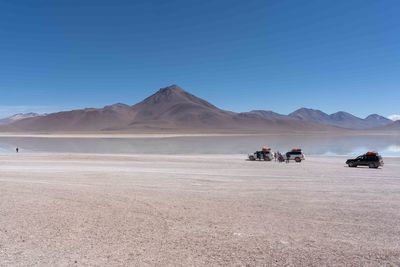 Scenic view of desert against clear blue sky