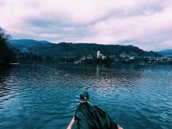 Boat in lake against cloudy sky