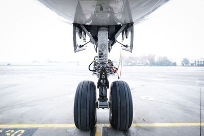 Airplane on airport runway against sky