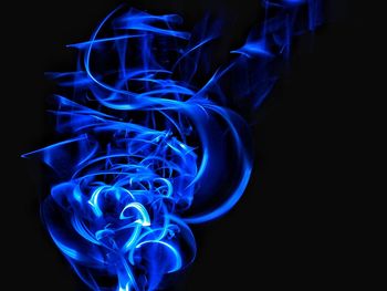Close-up of blue light painting against black background