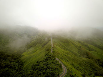 Countryside road passing through the lush green tropical rain forest mountain landscape