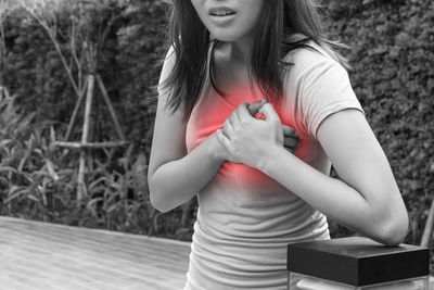 Midsection of woman standing against wall