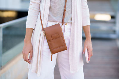 Midsection of woman standing in city