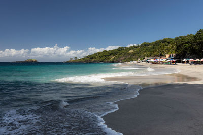 Gentle turquoise  waves at the white sand virgin beach in karangasem, bali, indonesia.