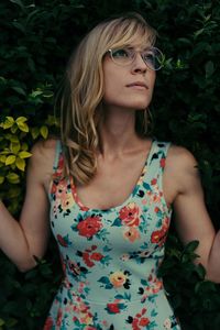 Close-up of young woman standing against plants